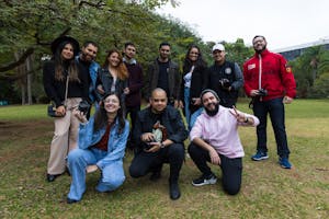 Diverse group of friends with cameras enjoying a photography meetup in a lush park setting.